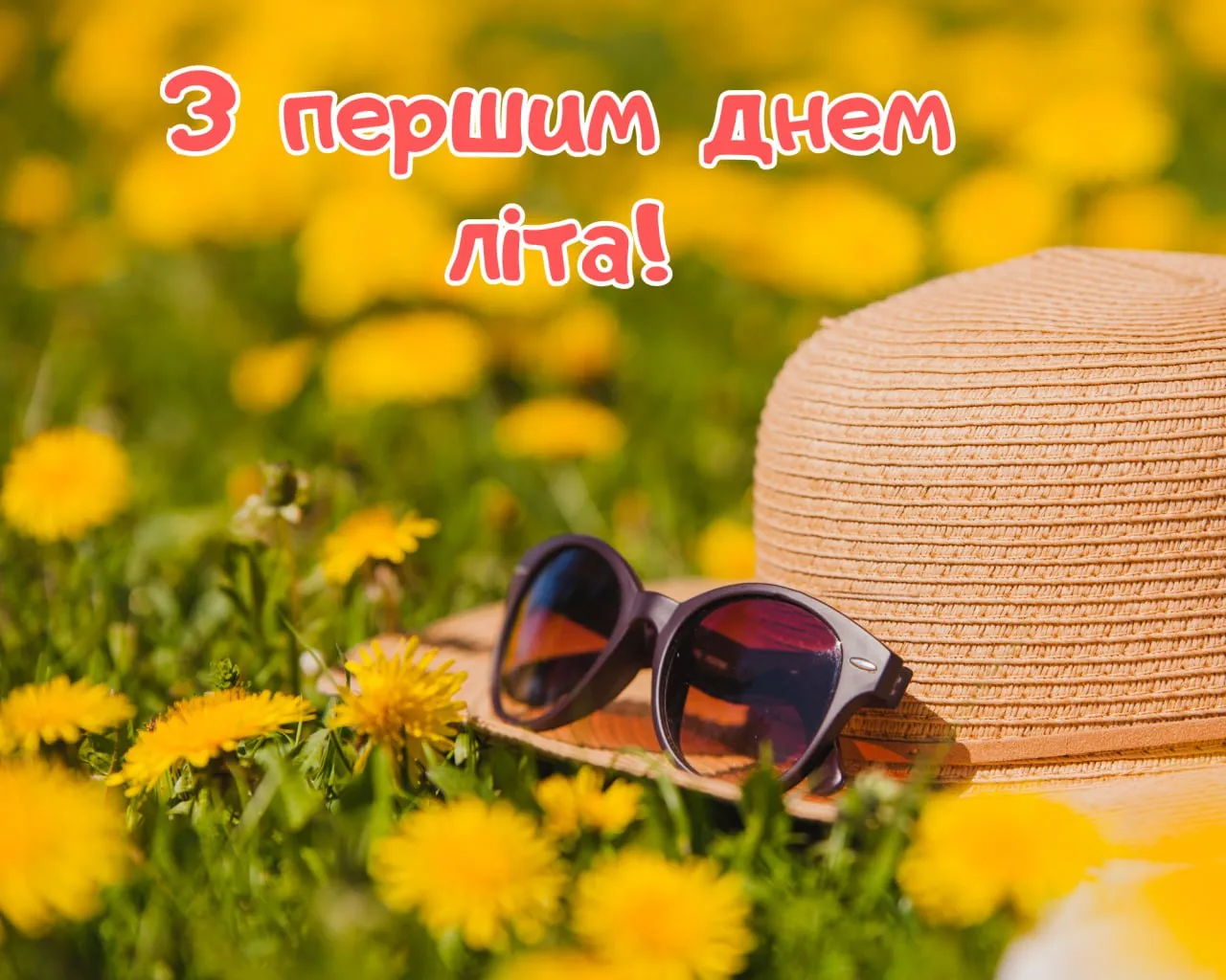 Жовті кульбади, солома капелюх та сонцезахисні окуляри на траві.