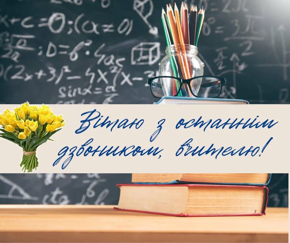 Квіти та підручники на парті вчителя з привітанням.