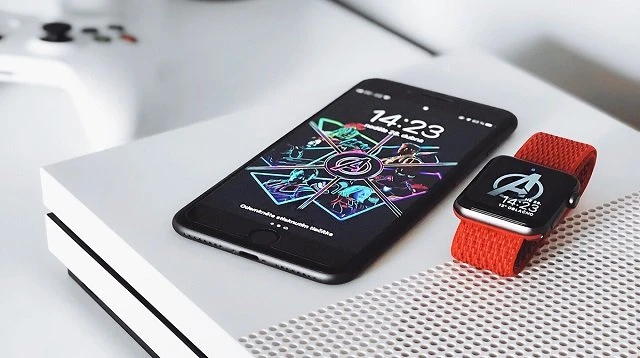 Чорний iPhone та годинник Apple Watch з червоним ремінцем