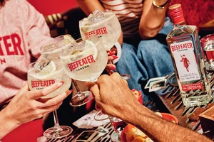 Люди піднімають склянки з джин-тоніком бренду Beefeater.